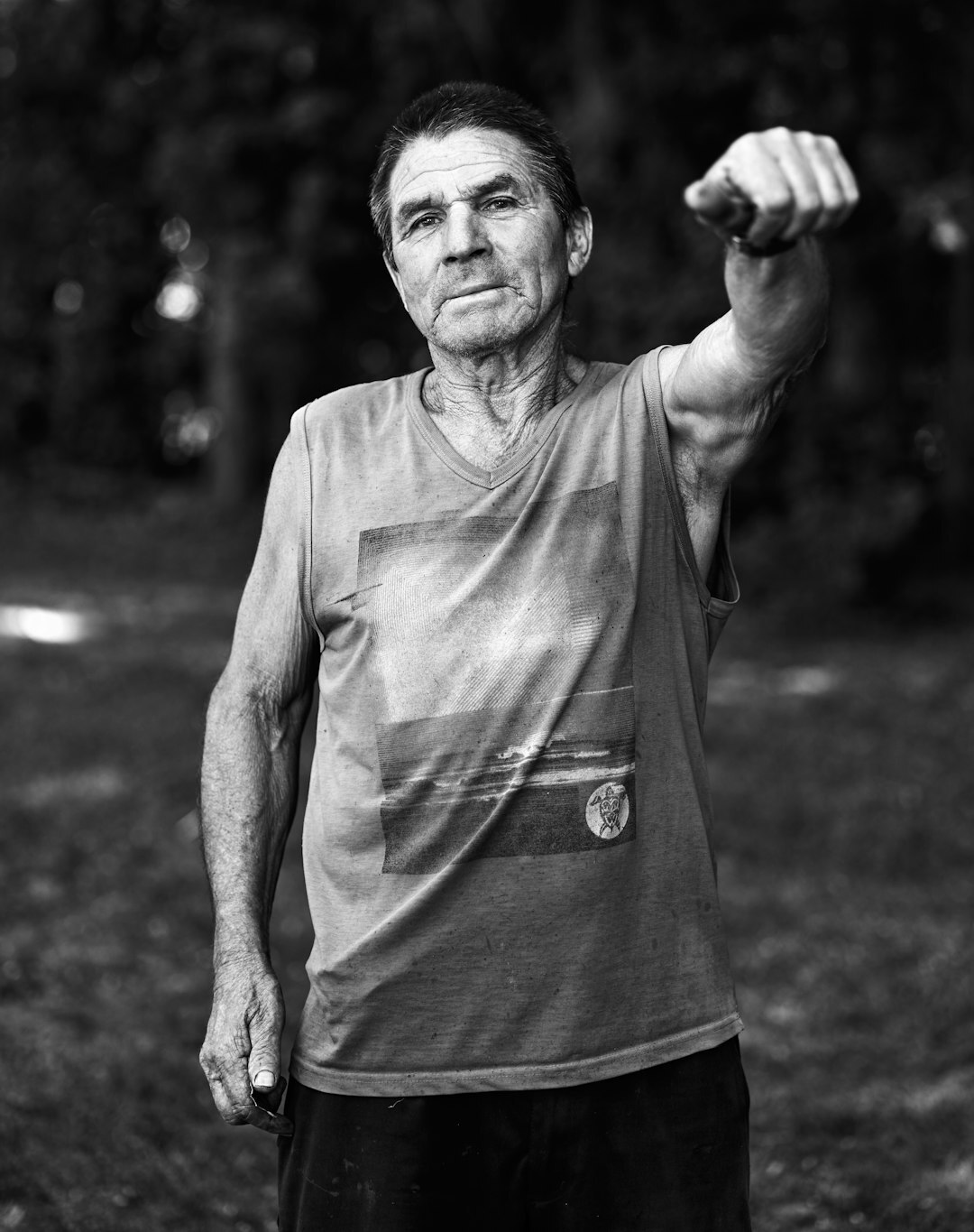 Portrait of an elderly Chilean man sitting on a wooden chair outside his house
